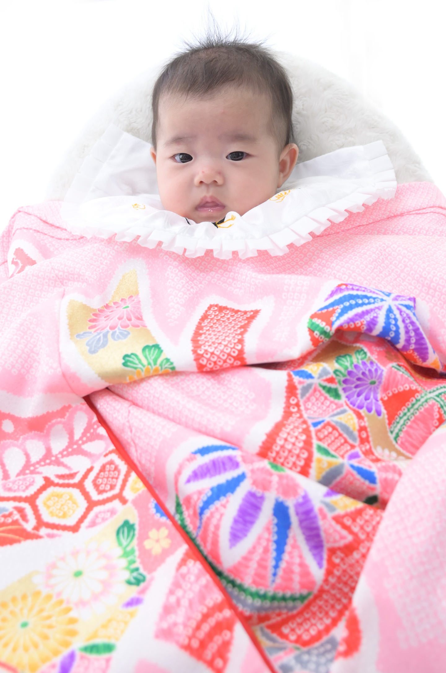 お宮参り写真/ピンクの掛け着の赤ちゃん